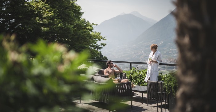 Paar beim Aperitiv auf der Gartenterrasse des 4 Sterne S Hotel Sonnbichl mit Blick auf Meran