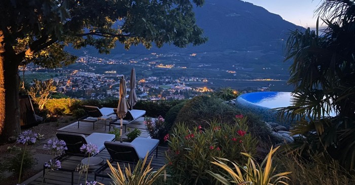 Abenddämmerung im Gartenpark des Park Hotel Sonnbichls mit Blick auf Meran umgeben von ausgewachsenen Bäumen