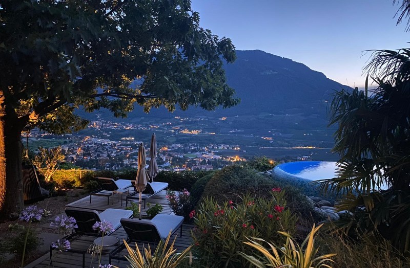 Abenddämmerung im Gartenpark des Park Hotel Sonnbichls mit Blick auf Meran umgeben von ausgewachsenen Bäumen